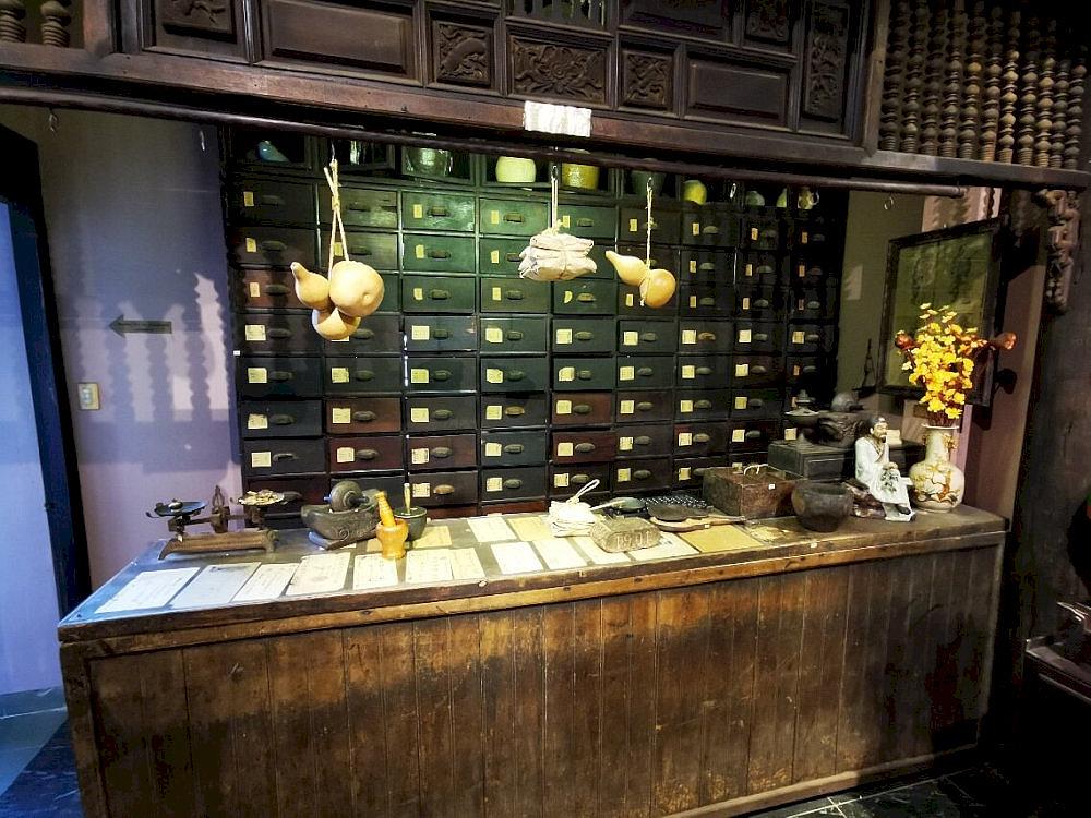 A large wooden medicine cabinet recreates a traditional 19th-century pharmacy in Vietnam